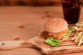 Tasty fish burger with fried potatoes wooden tray. Royalty Free Stock Photo
