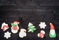 Tasty homemade gingerbread cookies with icing on dark wooden table, top view, flat lay. Christmas background with boder of santa, Royalty Free Stock Photo