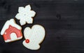 Tasty homemade gingerbread cookies with icing on dark wooden table, top view, flat lay. Christmas background with mitten. Royalty Free Stock Photo