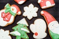 Tasty homemade gingerbread cookies with icing on dark wooden table, top view, flat lay. Christmas background. Royalty Free Stock Photo