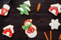 Tasty homemade gingerbread cookies with icing on dark wooden table, top view, flat lay. Christmas background with snowman. Royalty Free Stock Photo