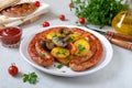 Tasty homemade grilled sausages with baked herb potatoes, mushrooms, cherry tomatoes and ketchup on a wooden background.