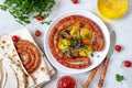 Tasty homemade grilled sausages with baked herb potatoes, mushrooms, cherry tomatoes and ketchup on a wooden background.