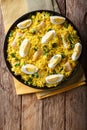 Tasty homemade Kedgeree with fish, boiled eggs, cilantro close-up on a plate. Vertical top view Royalty Free Stock Photo