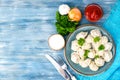 Tasty homemade meat dumplings of wholemeal flour, sprinkled with fresh parsley in plate on wooden table