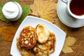 Tasty homemade pancakes and maple leafs on the table, top view. Warm golden autumn concept.