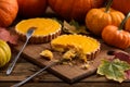 Tasty homemade pumpkin pies being eaten with forks on wooden boa