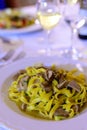 Tasty homemade tagliatelle pasta with fresh harvested boletus porcini mushrooms in creamy sauce