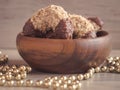 Homemade walnut rolls with dark chocolate in a wooden bowl and golden beads chain decoration, traditional Christmas sweets Royalty Free Stock Photo