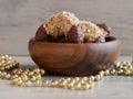 Homemade walnut rolls with dark chocolate in a wooden bowl and golden beads chain decoration, traditional Christmas sweets Royalty Free Stock Photo