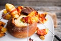 Tasty hot cheese fondue served in a bread roll with potatoes and Royalty Free Stock Photo