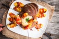 Tasty hot cheese fondue served in a bread roll with potatoes and Royalty Free Stock Photo