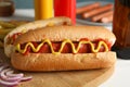 Tasty hot dogs, beer and sauces on wooden background