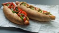 Tasty hot dogs on paper on grey background Royalty Free Stock Photo