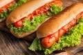 Tasty hot dogs with salad on wooden table, closeup Royalty Free Stock Photo