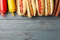 Tasty hot dogs and sauces on gray background