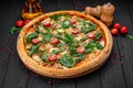 Tasty hot italian pizza on black wooden table. Royalty Free Stock Photo