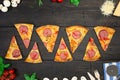 Tasty hot pizza with ingredients and pizza cutting knife on a black texture background. Top view
