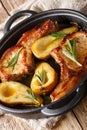 Tasty hot pork chops baked with pears and rosemary in honey sauce in a pan close-up. vertical Royalty Free Stock Photo