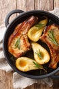 Tasty hot pork chops baked with pears and rosemary in honey sauce in a pan close-up. Vertical top view Royalty Free Stock Photo