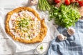 Tasty hungarian langos served with sour creme, ham, cheese, herbs and vegetables in the background