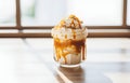 Tasty ice cream with caramel sauce in transparent mug on white wooden table for sweet dessert food card design Royalty Free Stock Photo