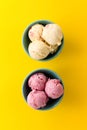 Tasty ice cream vanilla strawberry scoops in blue bowls on yellow vibrant background. Royalty Free Stock Photo