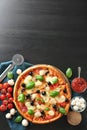 Tasty Italian pizza and ingredients on wooden background Royalty Free Stock Photo