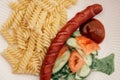 Tasty juicy spiral pasta Fusilli with salad, tomato, cucumbers, ketchup sauce, grilled hunter sausage white dish plate. Royalty Free Stock Photo