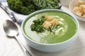 Tasty kale soup served on white wooden table, closeup