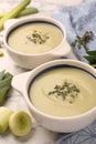 Tasty leek soup in bowls on white marble table Royalty Free Stock Photo