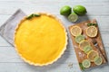 Tasty lemon pie and board with slices on light wooden table Royalty Free Stock Photo