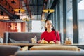 Beaming woman with red lips eating tasty lunch in restaurant