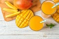 Tasty mango drink and fresh fruits on wooden table Royalty Free Stock Photo
