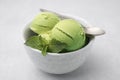 Tasty matcha ice cream and spoon in bowl on light grey table, closeup Royalty Free Stock Photo