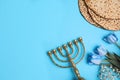 Tasty matzos, flowers and menorah on light blue background, flat lay with space for text. Passover Pesach celebration Royalty Free Stock Photo