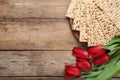 Tasty matzos and flowers on table, flat lay with space for text. Passover Pesach Seder