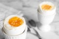 Tasty medium boiled egg in ceramic holder on table, closeup