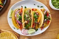Tasty mexican tacos with beef fajita filling served with salsa and guacamole in flat lay composition