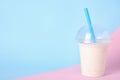 Tasty milk shake in plastic cup on color background. Space for text Royalty Free Stock Photo