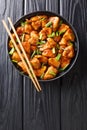Tasty Mongolian chicken cooked in a spicy sweet sauce close-up in a plate. Vertical top view