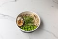 tasty noodle soup bowl with green beans and an egg on the marble table