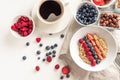 Good morning - healthy breakfast background with oatmeal coffee, berries, egg, nuts. White wooden food background,