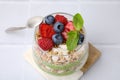 Tasty oatmeal with chia matcha pudding and berries on white tiled table, above view. Healthy breakfast Royalty Free Stock Photo