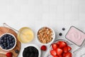 Tasty oatmeal, fresh berries, yogurt and honey on white tiled table, flat lay with space for text. Healthy breakfast Royalty Free Stock Photo