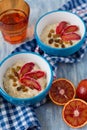 Tasty oatmeal with sicilian orange slices and raisins on blue bowls Royalty Free Stock Photo