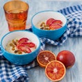 Tasty oatmeal with sicilian orange slices and raisins on blue bowls Royalty Free Stock Photo