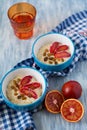 Tasty oatmeal with sicilian orange slices and raisins on blue bowls Royalty Free Stock Photo