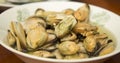 Tasty oiled pickled mussels iin a plate on the table