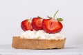 Sandwich from red strawberry, white cottage cheese and bread on the white wooden table, close up Royalty Free Stock Photo